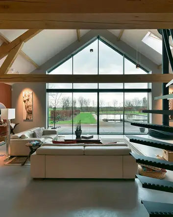 Betonvloer in moderne woonkamer met houten balken, witte meubels en panoramische ramen, strakke stijl met natuurlijke elementen