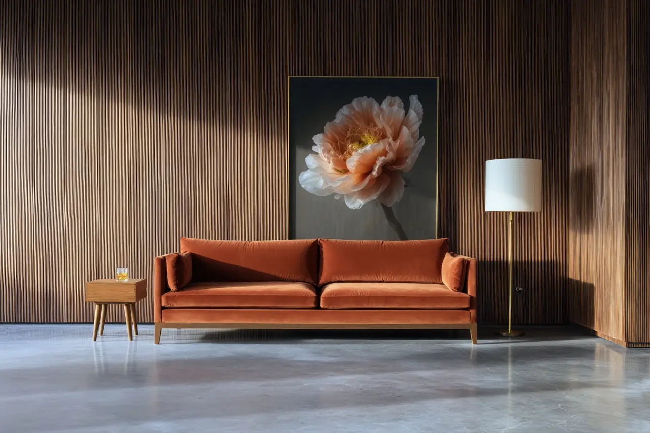 Elegante woonkamer met woonbetonvloer, houten wand, oranje fluwelen bank en bloem schilderij