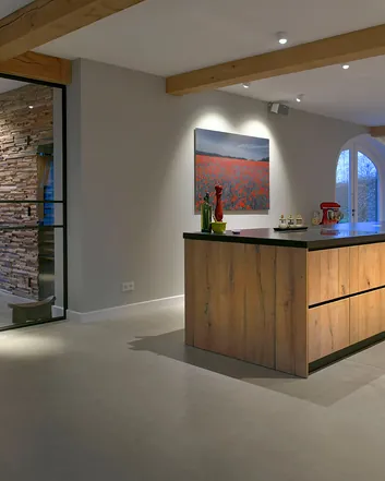 Woonbetonvloer in moderne woonruimte met houten keuken, witte muren en houten balken, minimalistisch en ruimtelijk indeling