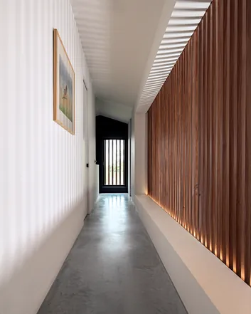 Modern interieur van een hal met betonnen vloer, houten wandpanelen en een schilderij aan de muur