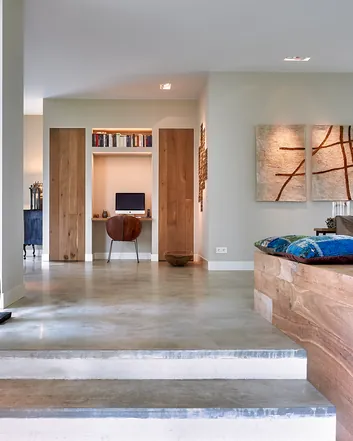 Modern interieur met betonvloer, houten meubels en kunstwerk