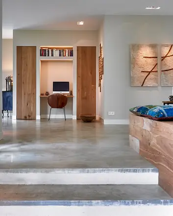 Modern interieur met betonvloer, houten meubels en kunstwerk
