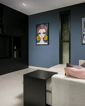 Een moderne kamer met woonbeton, grijze bank en kunst aan de muur